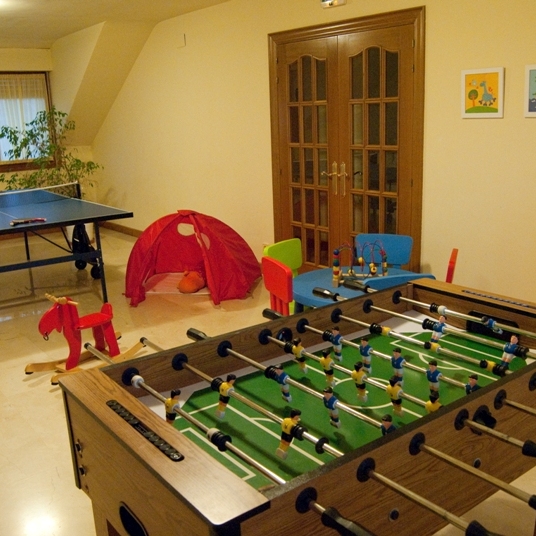 Sala de juegos, con ping-pong, juguetes para niños y futbolín